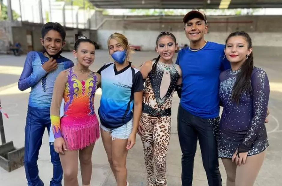 El entrenador Dylan Alba junto a destacas/os patinadores.