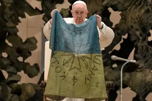 Francisco bes una bandera ucraniana de Bucha y conden la horrenda crueldad de la masacre