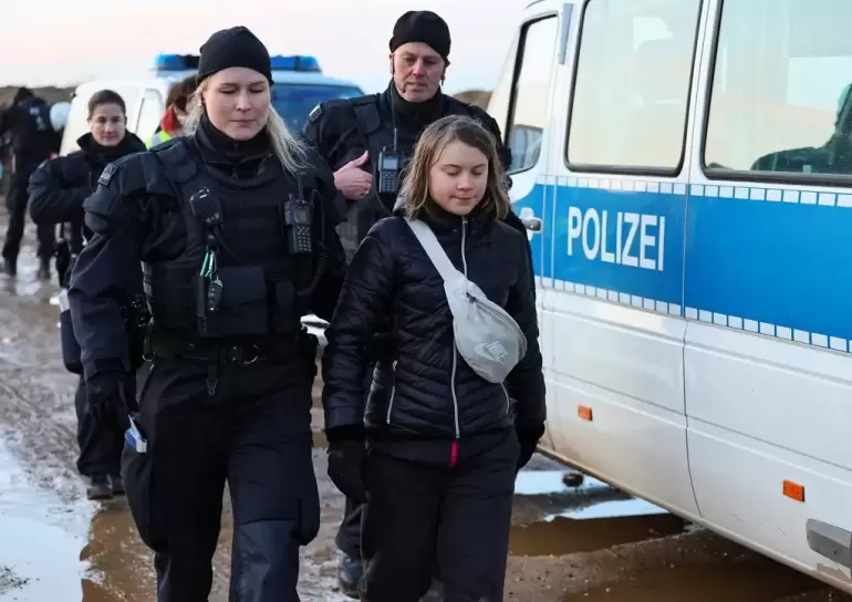 Greta Thunberg es acompaado por una polica (Foto: Reuters)