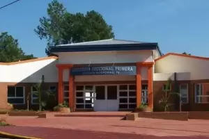 Una mujer at las manos de su hija para golpearla con un palo de escoba