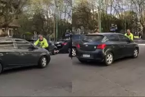 Una mujer estacion en doble fila, y para evitar la multa choc al agente de trnsito