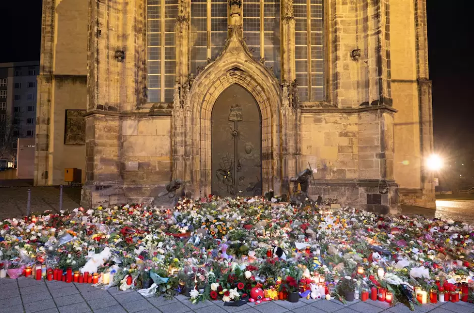 Velas, flores y guirnaldas frente a la entrada de la iglesia de San Juan
