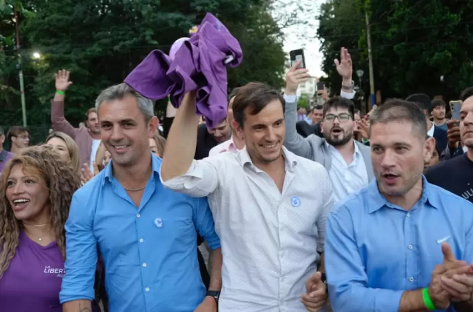 Diego Hartfield levanta una remera violeta de La Libertad Avanza